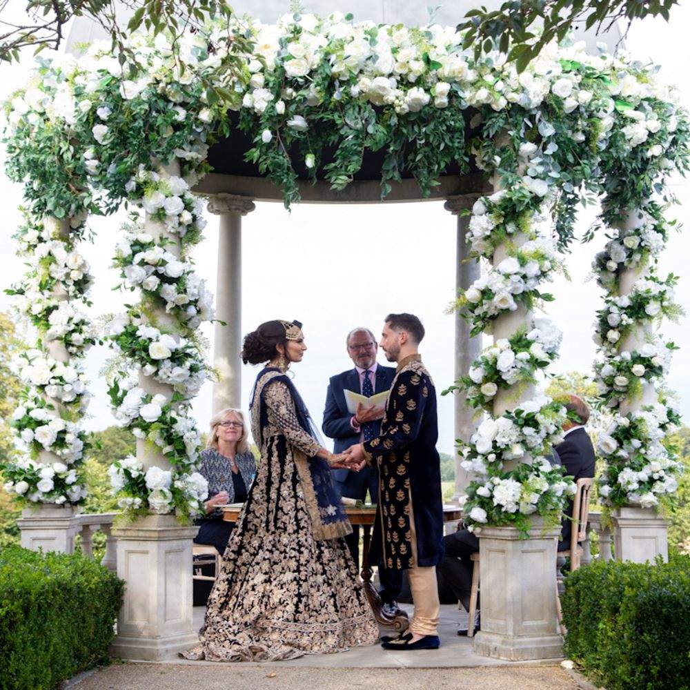 An South Asian Bride & Groom exchange their wedding vows outdoors at Froyle Park