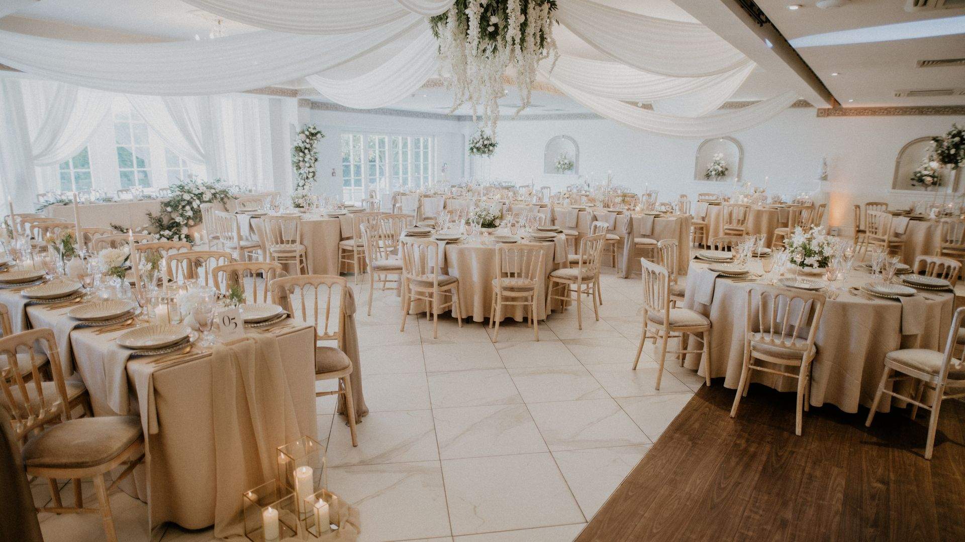 A beautiful wedding setup in Froyle Park's Grand Ballroom, featuring elegant white draping.