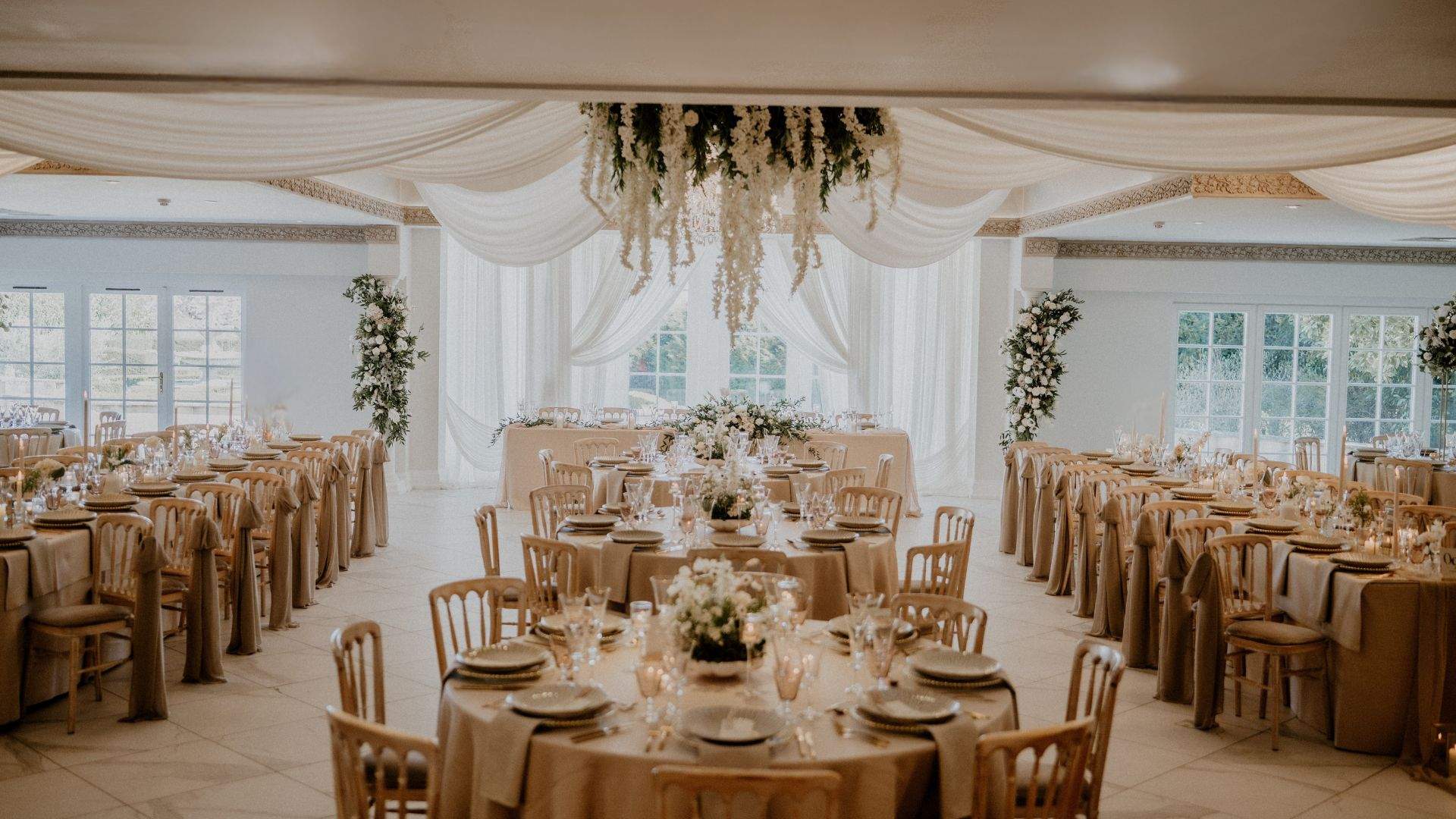 A beautiful wedding setup in Froyle Park's Grand Ballroom, featuring elegant white draping.