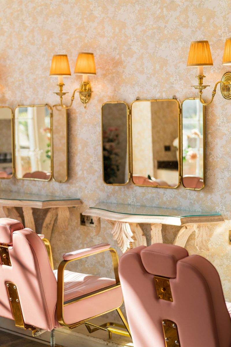 Froyle Park is a wedding venue in Surrey with a purpose-built getting ready space for the Bridal called the Hideaway, featuring mirror stations and pink salon chairs.