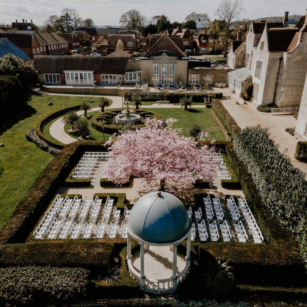 Arial view of Froyle Park, showing the gardens, ceremony dome, fountain and stunning cherry blossom tree in full, pink bloom