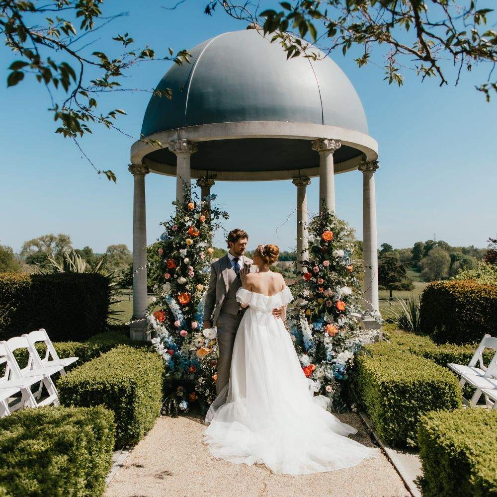 A stunning Bride & Groom exchange vows at Froyle Park's iconic outdoor ceremony location in Hampshire - the Dome