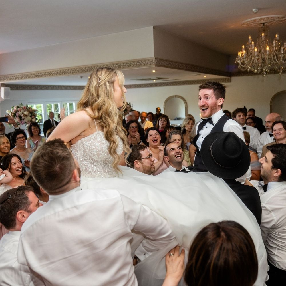 A Jewish bride and groom enjoy the Hora at their wedding reception at Froyle Park