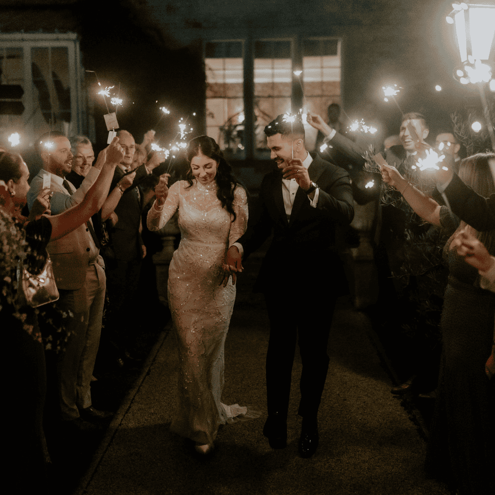 A bride and groom enjoy a sparkler procession at Froyle Park
